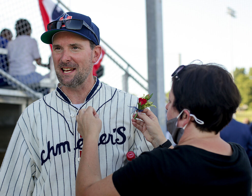 Pete Gorton pauses to let his wife pin a red rose to his baseball jersey
